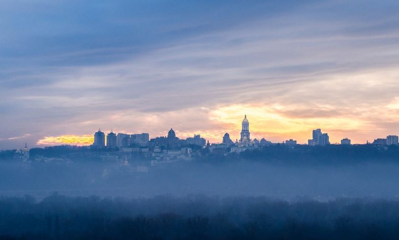The Kyiv skyline at dawn above a layer of mist